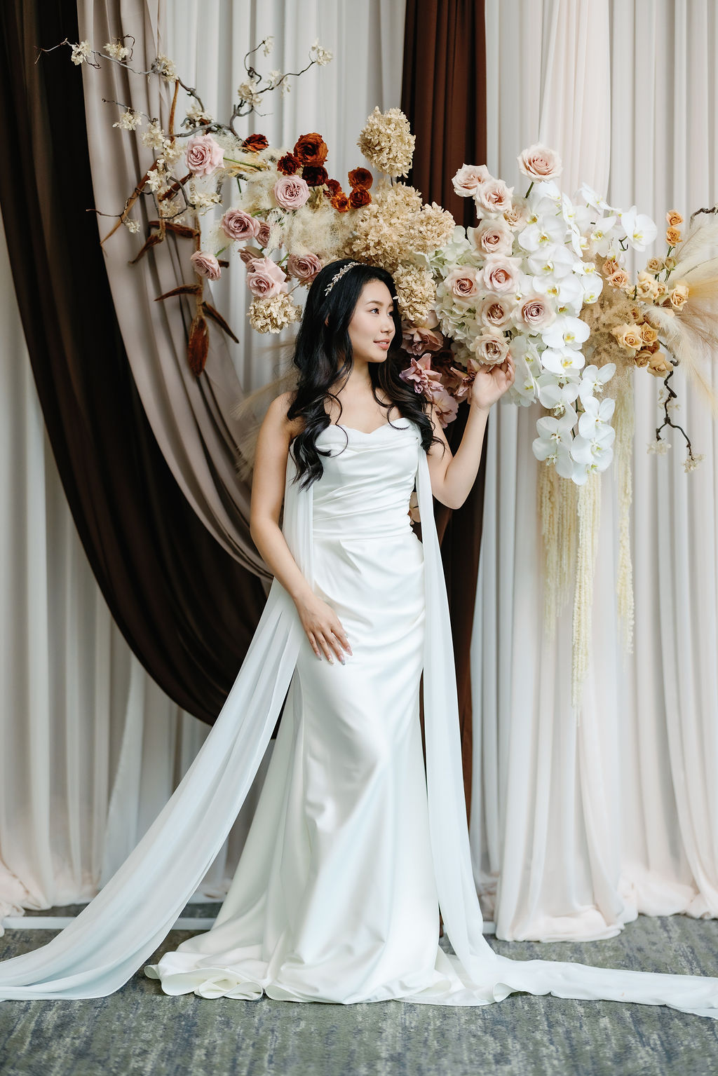bride poses by roses and hydrangeas