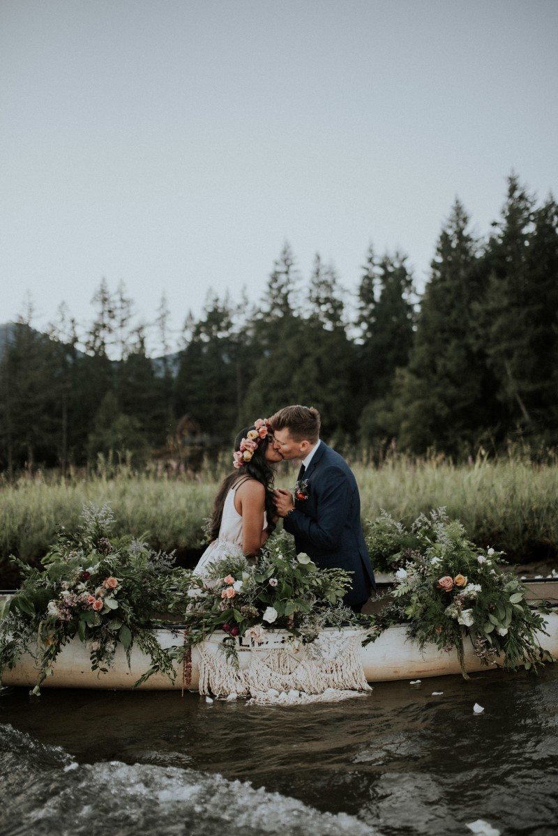 eloping couple kiss in canoe