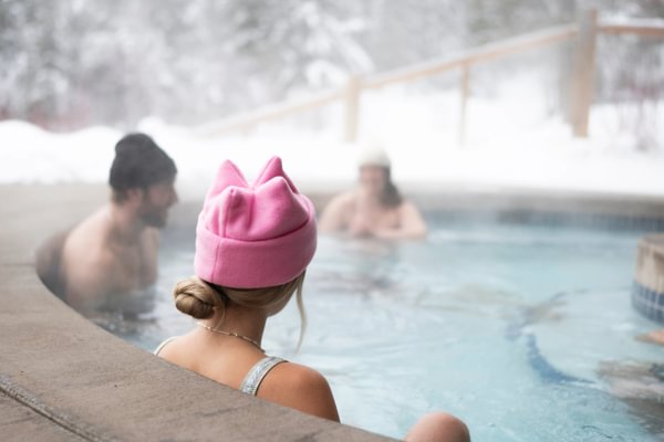 Guests sit in Tyax Lodge Spa pool in snow