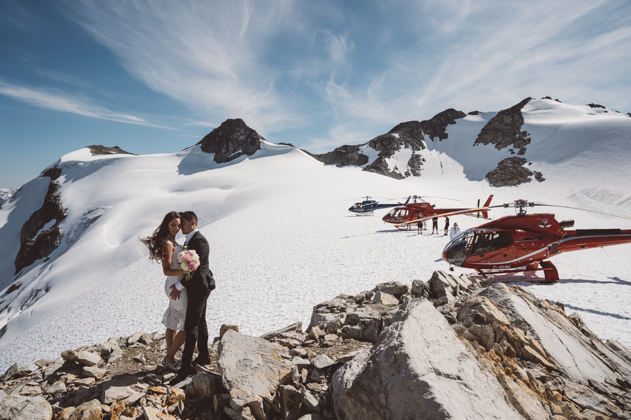 Eloping couple in front of helicopters in Rocky Mountains